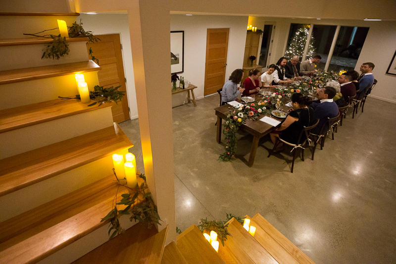 An elegant wedding dinner table set up in the walkout finished basement with family and friends gathered