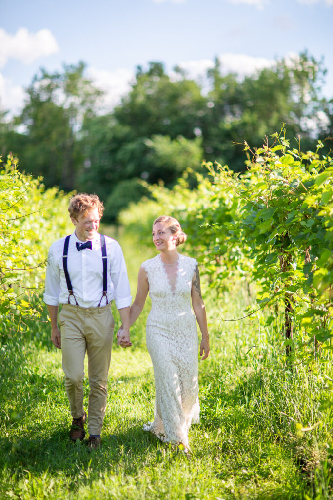 Couple walks through the grapevines at Shelburne Vineyard