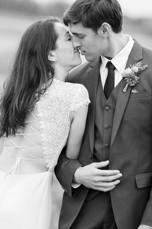 A Vermont small wedding couple kisses in a farmers field not from from Starry Night Cafe