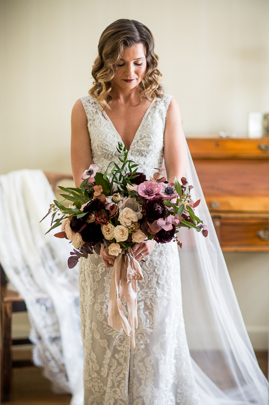 Bride just before the ceremony looks down at her flowers in the bridal suit at the Grafton Inn, Grafton, Vermont