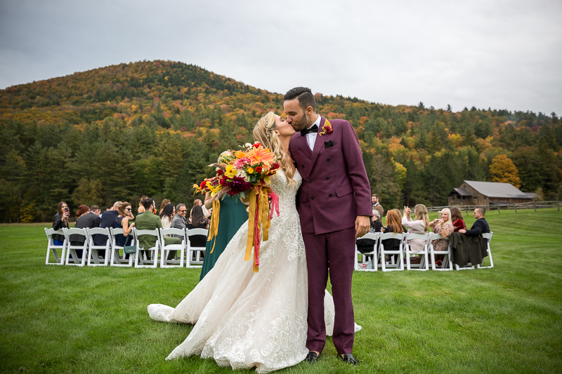 The bride and groom kiss at the end of the aisle just after the wedding ceremony