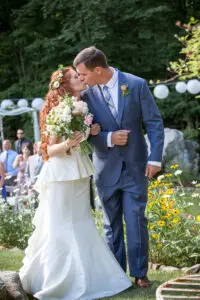 Bride and groom kiss at the top of their aisle just after they were married in the garden at the Notch House