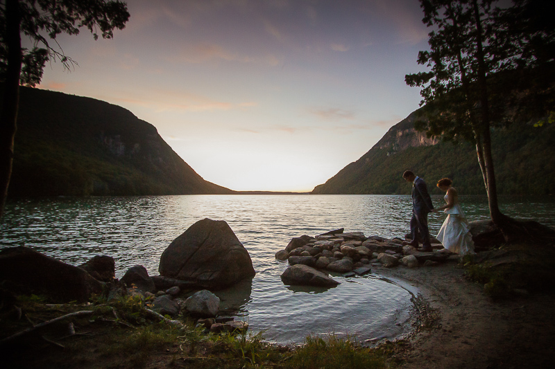 The bride and groom on the shore of Lake Willoughby at twilight