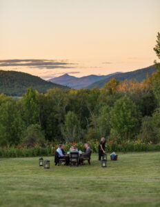 An intimate dinner set up in a field on a perfect Vermont summer evening