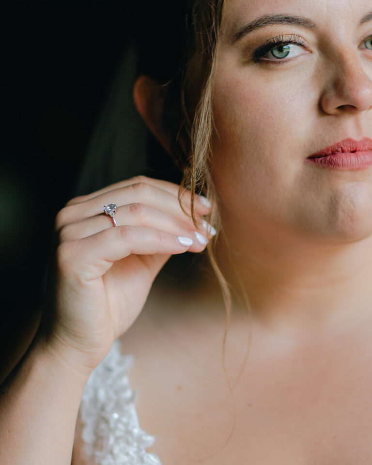 A detail of a bride holding her earring