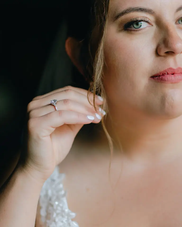 A detail of a bride holding her earring while looking at her vermont wedding photographer