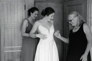 Mom and Sister help the bride into her dress at Jay Peak Vermont Tram Haus
