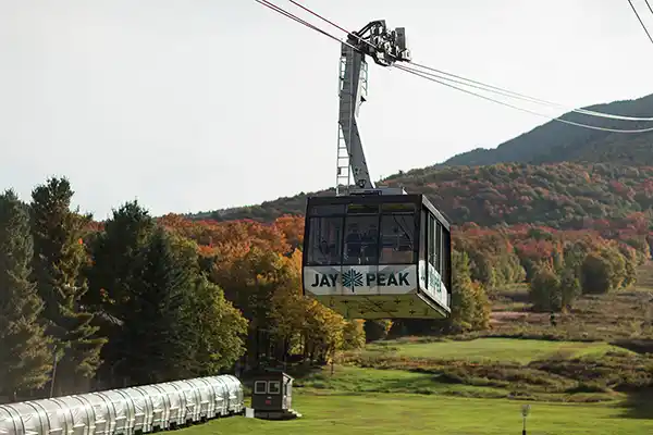 Wedding party rides gondola to summit ceremony at Jay Peak Resort surrounded by Vermont fall foliage.