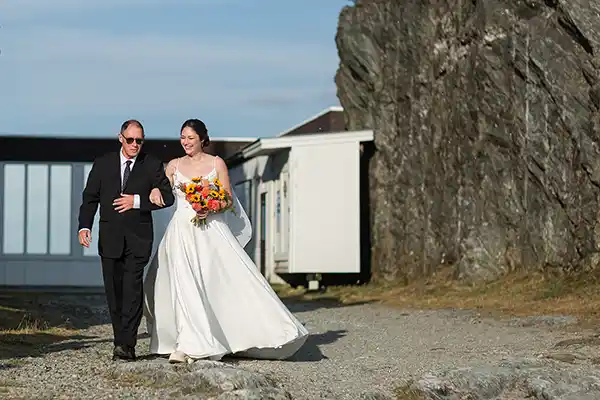 Bride walks down the aisle at outdoor summit wedding ceremony at Jay Peak Resort Vermont with fall foliage in background.