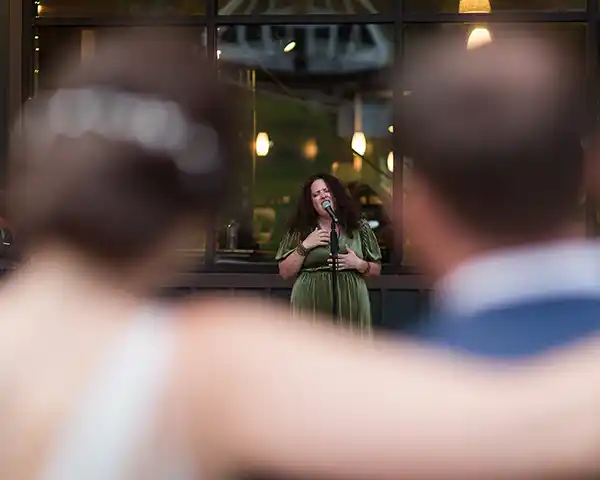 Friend performs vocal songs during cocktail hour at Jay Peak Resort Vermont fall wedding reception.