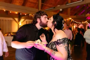A couple kisses at their cake cutting