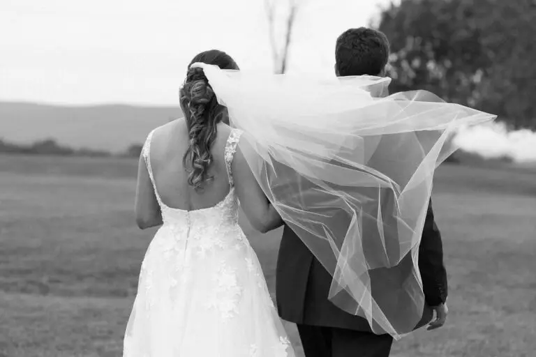 a brides veil blows across her fathers back as they walk away at Tourterelle