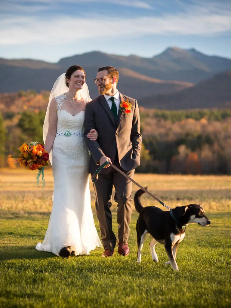 bride and groom walk with their dog.