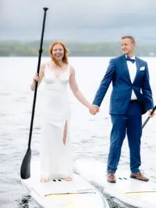 A couple paddle boards on their adventure elopement day in Vermont