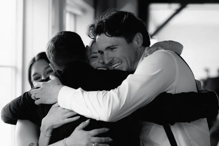 The groom and bride hugs their best man and maid of honor after the toast