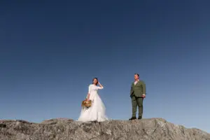 bride and groom on the summit of Jay peak in vermont