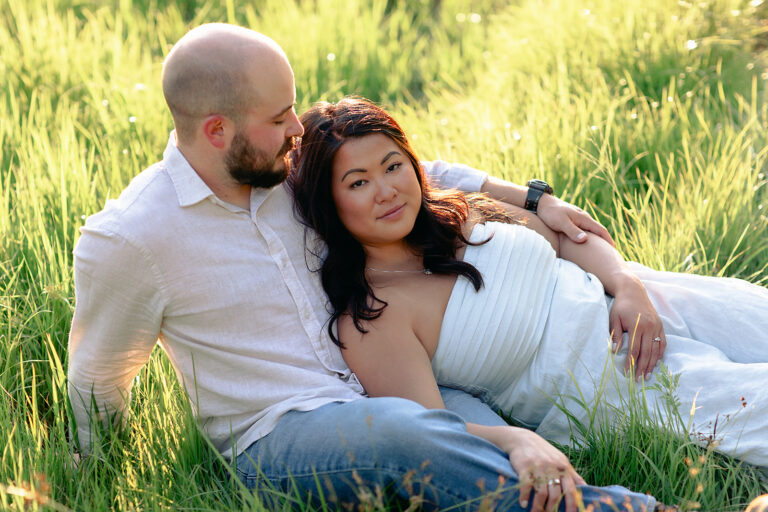 a bride to be leans on her partner in a grass sun lit field in Vermont