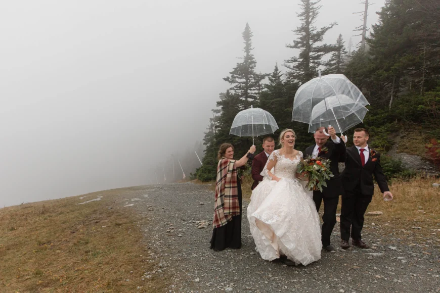 A bride is covered by umbrellas on the sumit of Mount Mansfield at the Stowe Ski Resort, Vermont