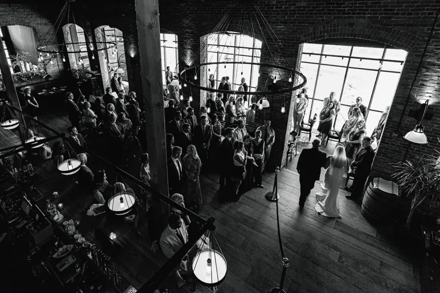 A view from the upper balcony, Dad walks his daughter down the aisle at Waterworks Restaurant Vermont