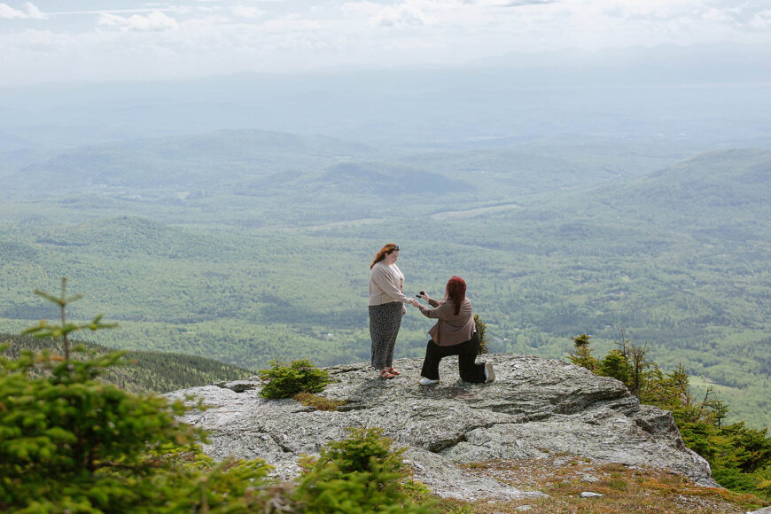 Two ladies get engaged on Vermont's highest peak. She said yes on top of mount Mansfield with an epic view of the land below behind them