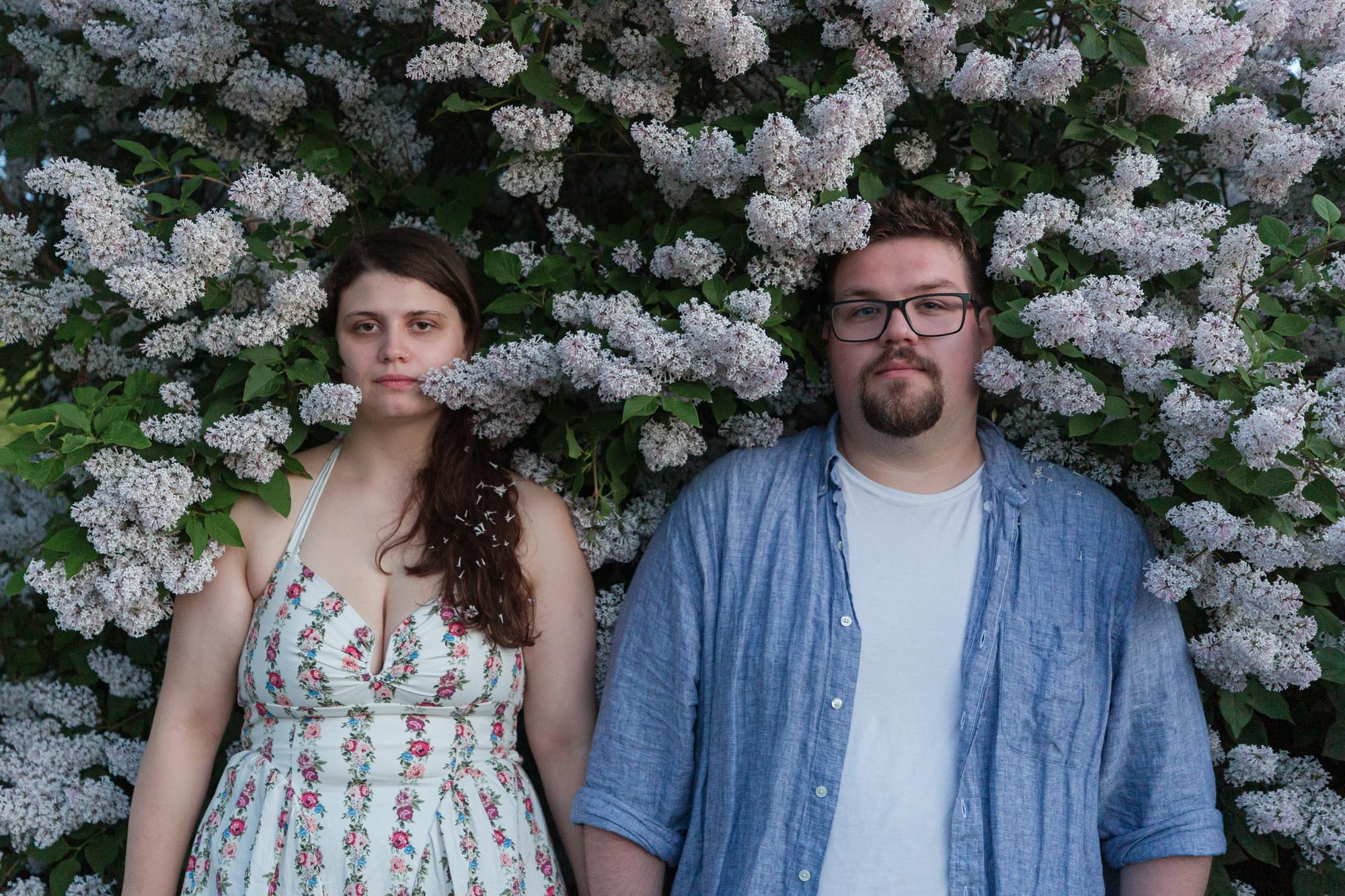 A fun image of a couple leaning in to lilacs in the formal garden at the Shelburne Farms Inn