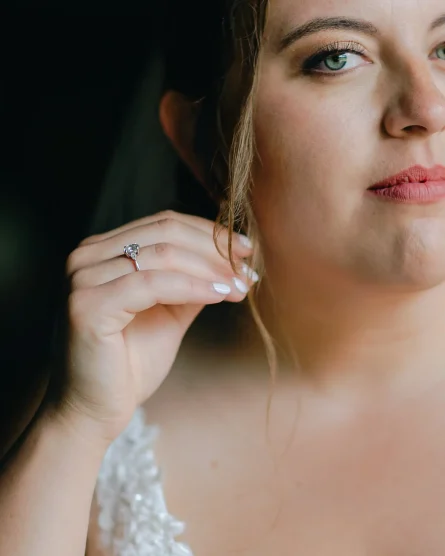 A detail of a bride holding her earring while looking at her vermont wedding photographer