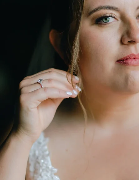 A detail of a bride holding her earring while looking at her vermont wedding photographer
